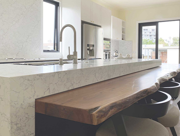 Modern kitchen with marble countertops, large wooden island, stainless steel appliances, and bright windows. Modern kitchen with marble countertops, large wooden island, stainless steel appliances, and bright windows.