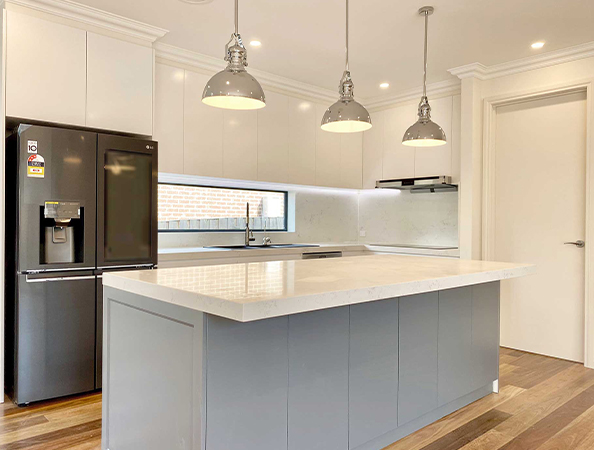 Modern kitchen with a large island, white and gray cabinets, stainless steel appliances, and pendant lights. Modern kitchen with a large island, white and gray cabinets, stainless steel appliances, and pendant lights.