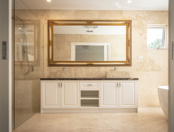 Elegant bathroom with large mirror, dual sinks on a marble-topped white vanity, and glass shower enclosure. Elegant bathroom with large mirror, dual sinks on a marble-topped white vanity, and glass shower enclosure.