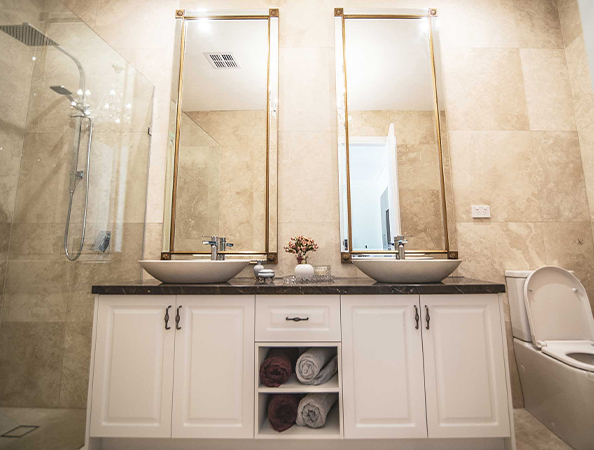 Bathroom with twin sinks, large mirrors, and white cabinetry. Includes a shower, towels, and a toilet on the right. Bathroom with twin sinks, large mirrors, and white cabinetry. Includes a shower, towels, and a toilet on the right.