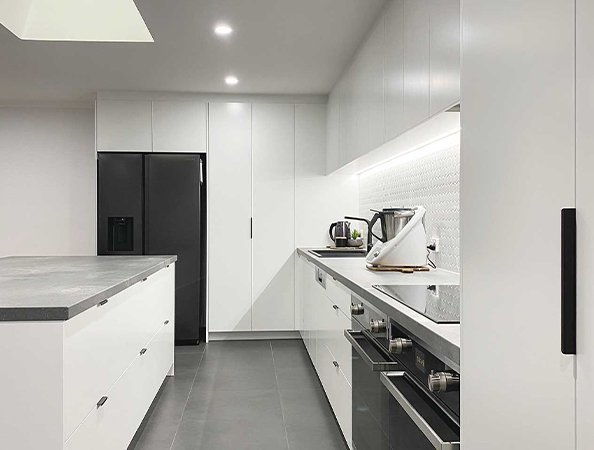 Modern kitchen with white cabinets, black appliances, and a sleek countertop. Modern kitchen with white cabinets, black appliances, and a sleek countertop.