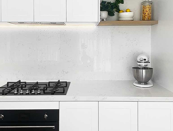 Modern kitchen with white cabinets, gas stove, mixer, and shelf holding plants and a jar. Modern kitchen with white cabinets, gas stove, mixer, and shelf holding plants and a jar.