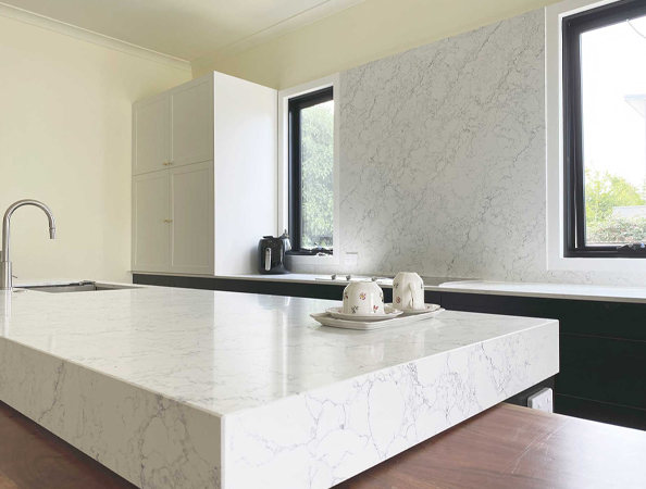 Modern kitchen with marble countertop, black cabinets, and large windows.