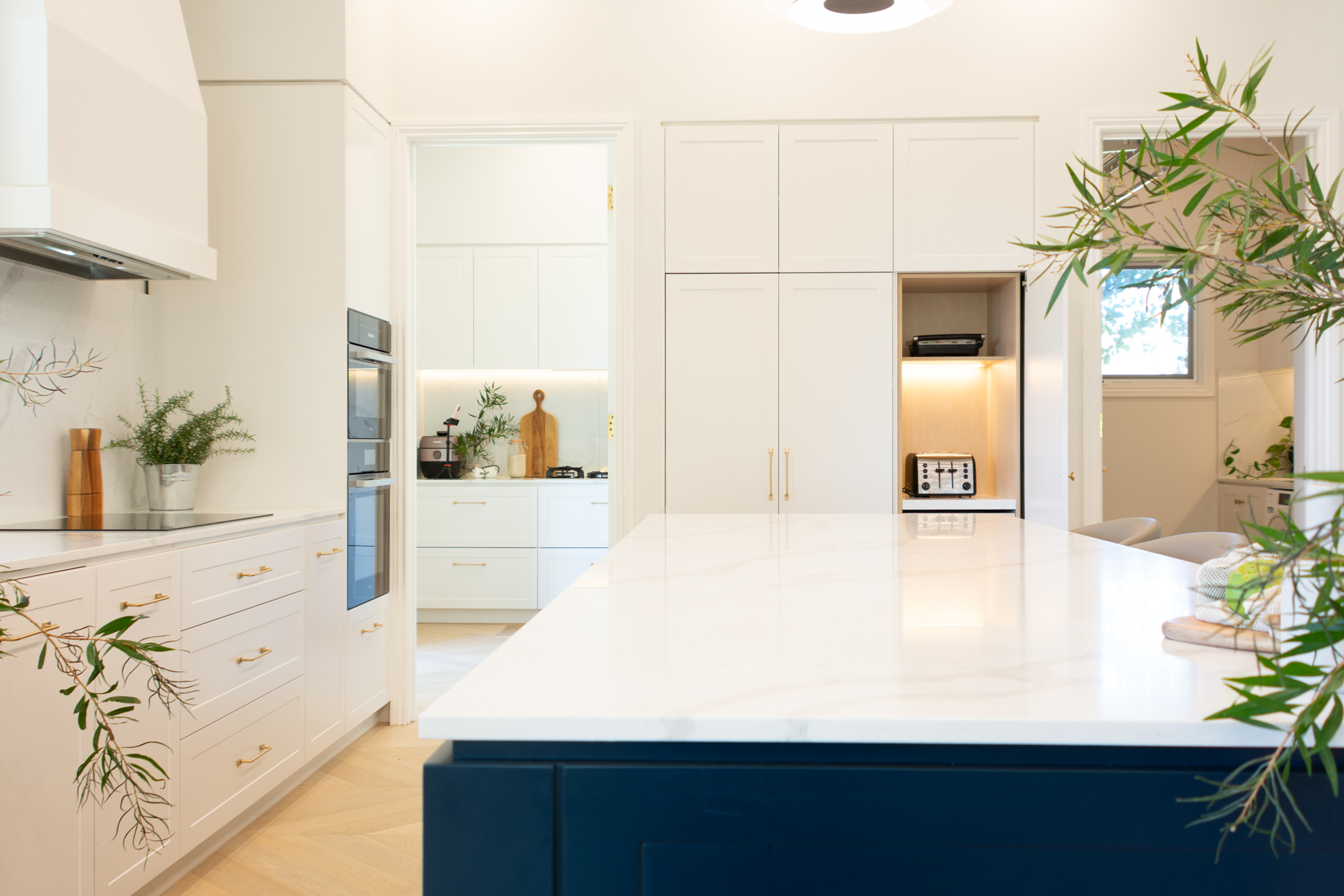 Custom kitchen with navy island bench, white cabinetry and stone benchtop, Canterbury Custom kitchen with navy island bench, white cabinetry and stone benchtop, Canterbury